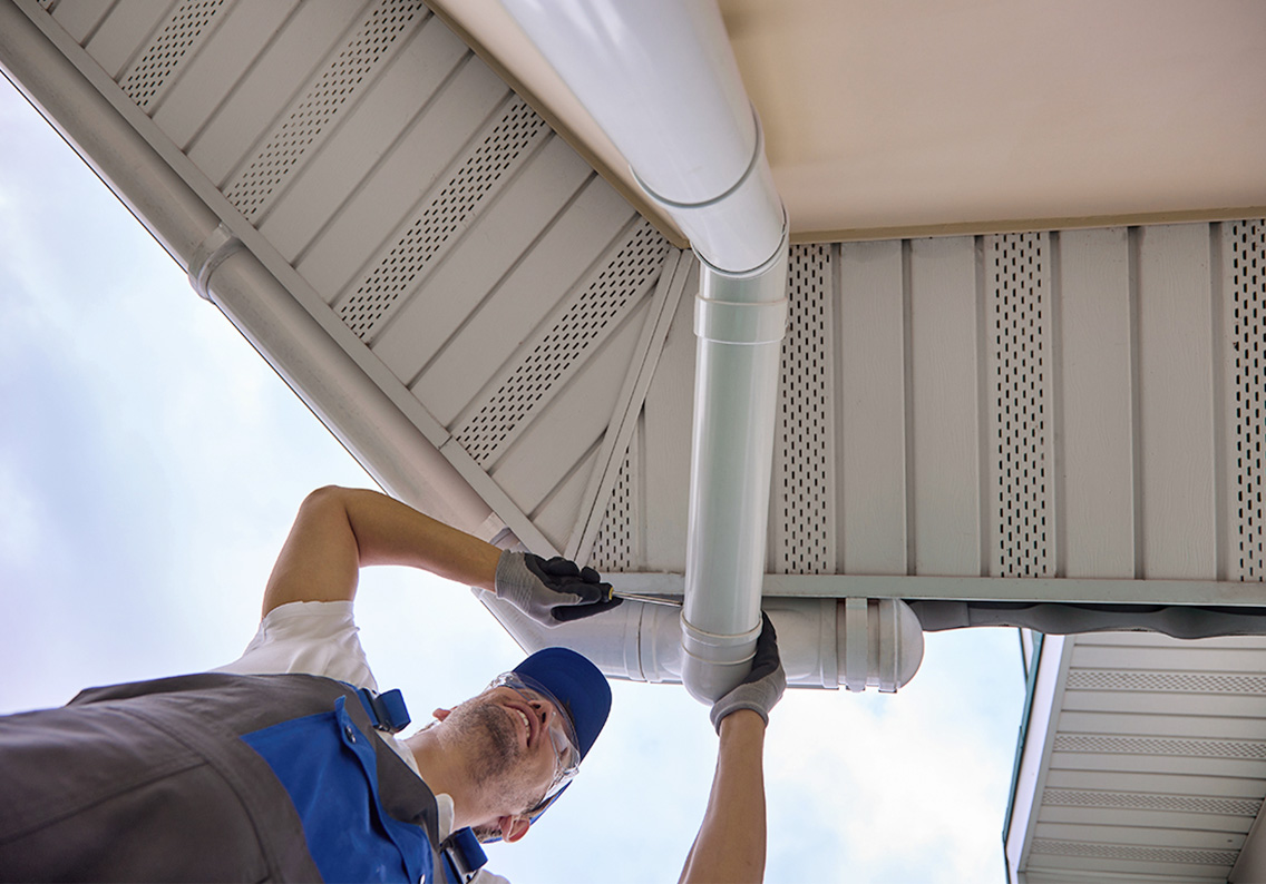 upward shot of man hanging gutter